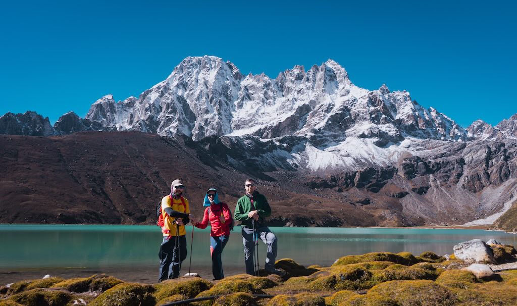 Three trekkers on their Gokyo Lakes Trek posing for a photo in front of Dudh Cho